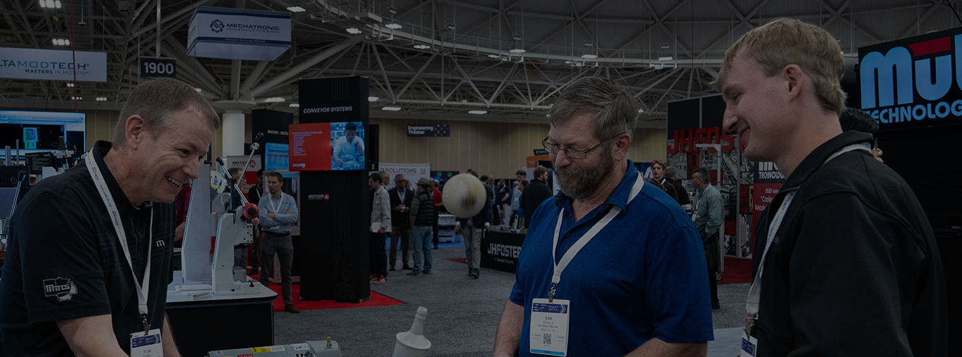 Exhibitor speaks to two attendees