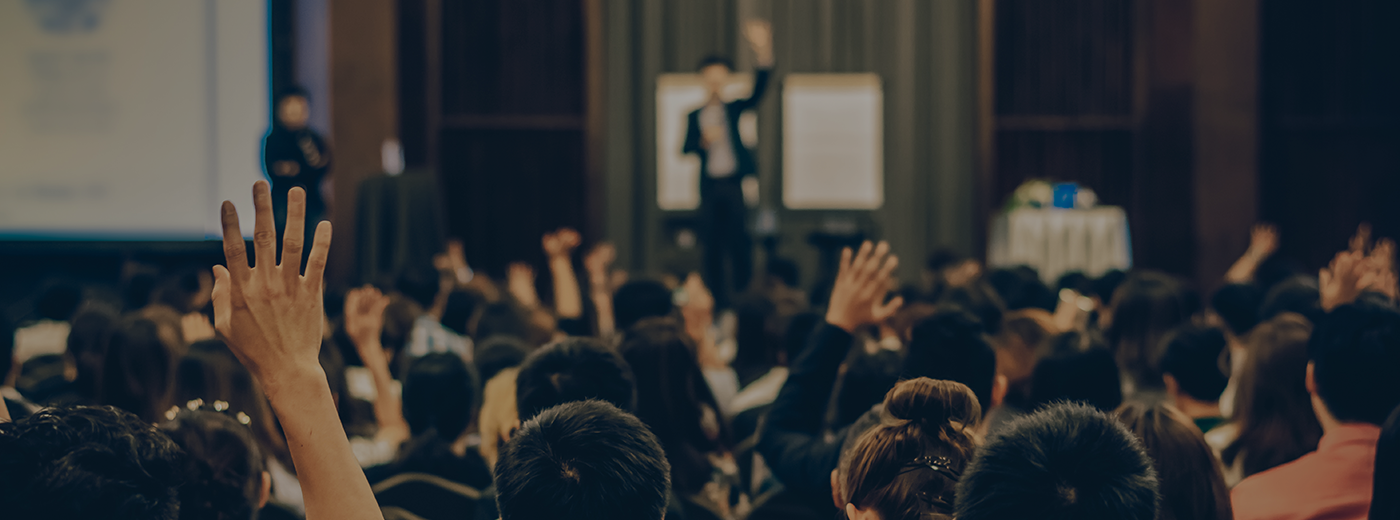 Speaker on the stage with Rear view of Audience in the conference hall or seminar meeting, business and education concept