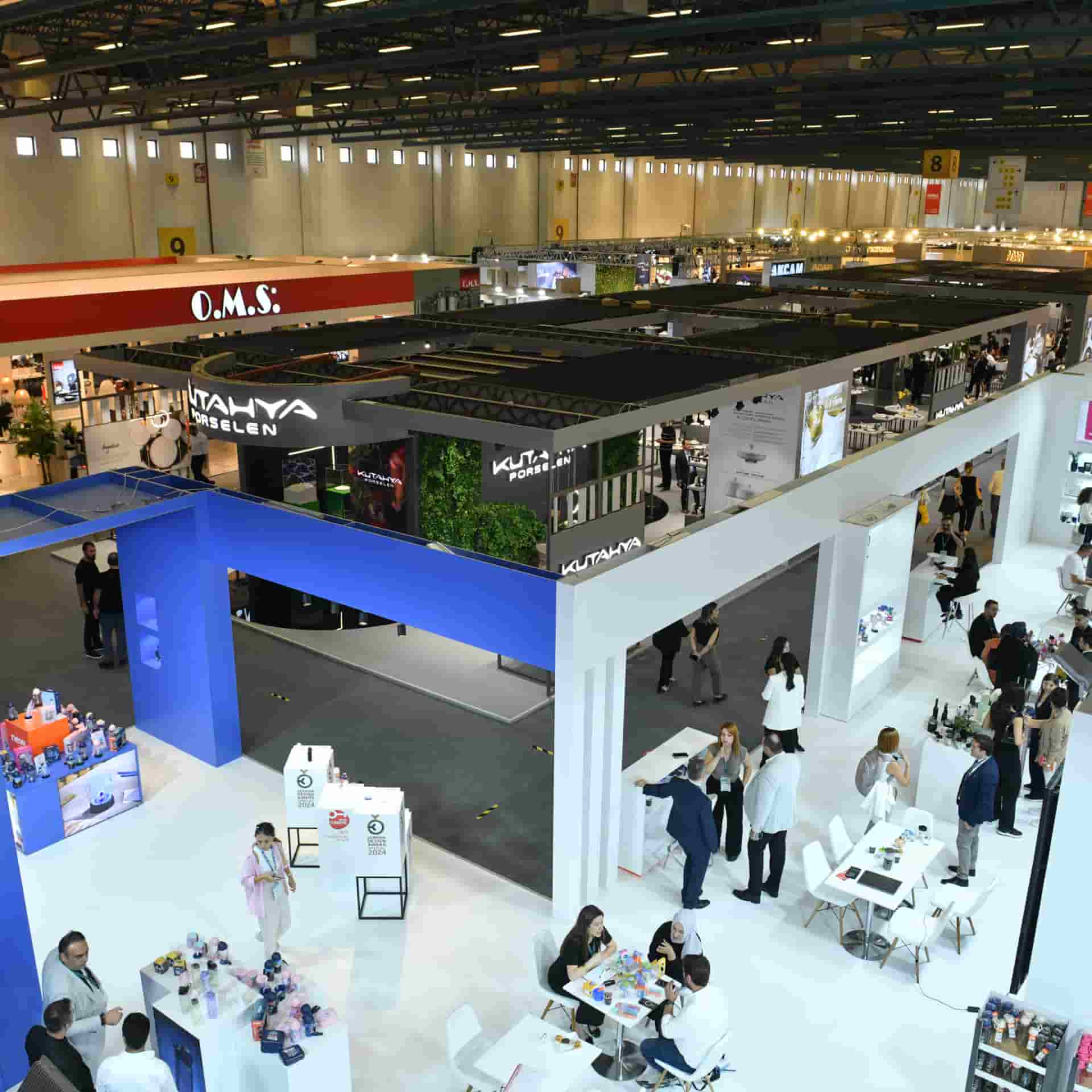 An overhead view of the hall with exhibitor stands and visitors exploring products and chatting.