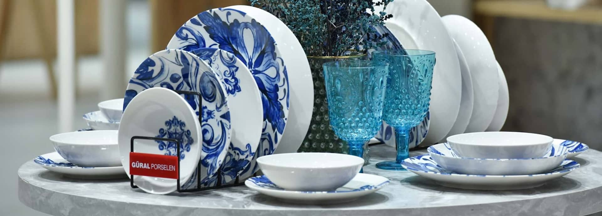 Mavi tabaklar ve mavi bardaklarla hazırlanmış sofra takımı ürün grubu görseli.