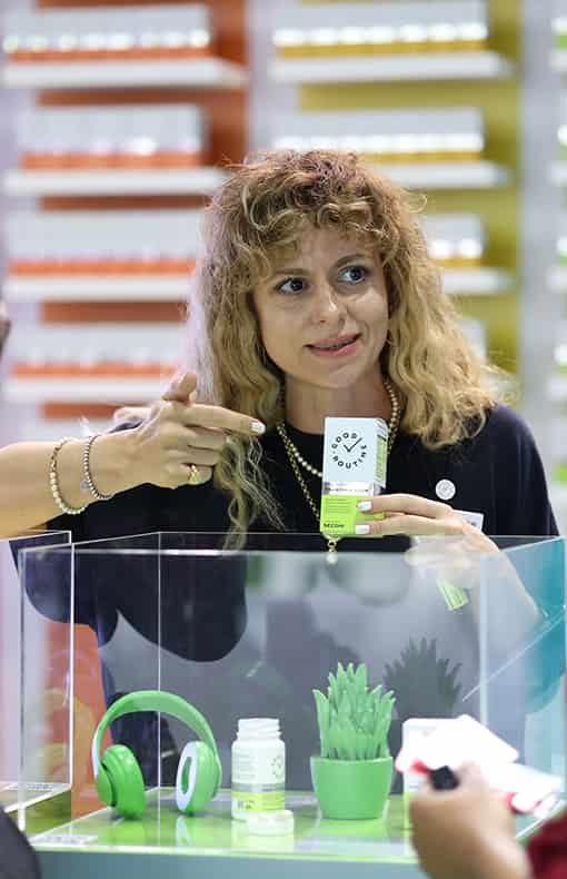 Exhibitor at Vitafood Asia event showcasing her product within a display case