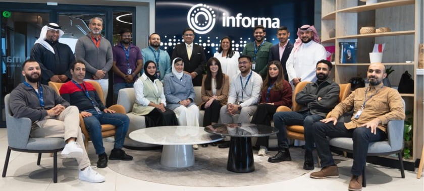 Group of Informa leaders engaged in a strategic discussion, showcasing collaboration and leadership in a professional setting