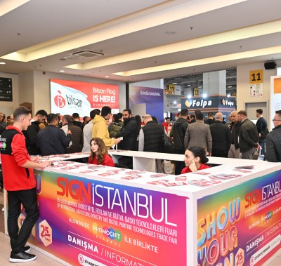 Attendees gathering at the registration desk for SIGN İstanbul receiving event materials and badges
