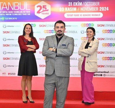 Three SIGN İstanbul team members posing confidently in front of the event backdrop on a red carpet