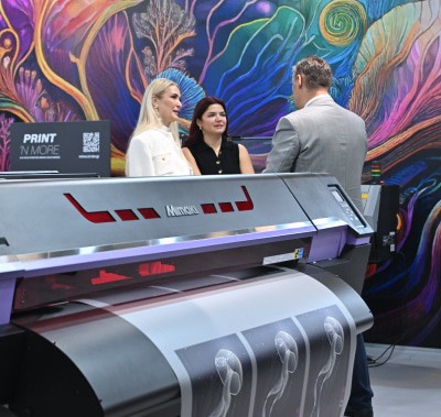 Visitor interacting with a large-scale printing machine at SIGN İstanbul
