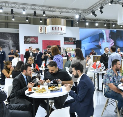 Zuchex 2025'teki ortak alanda yemek yiyen ve içki içen ziyaretçiler.