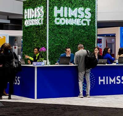 HIMSS Connect counter with staff speaking with visitors