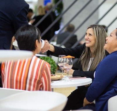 Three females in suits sat down having a meeting