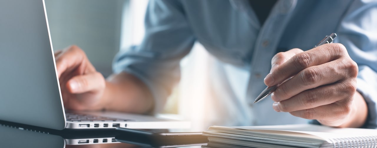 Person writing notes from the connection opportunities from laptop